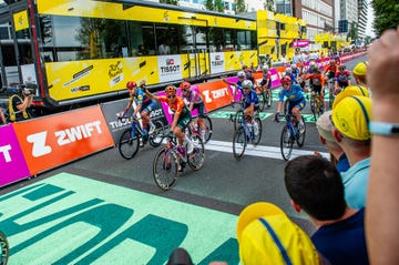 people are seen cheering the cyclists arriving at the finish