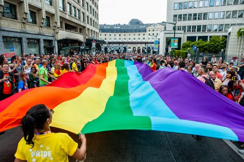 People are seen holding a big rainbow flag during the parade...