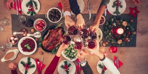 people clinking wine glasses at christmas table