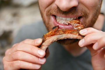 people eat food man eating barbecue ribs in grill bar closeup