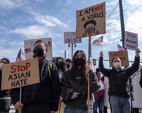 people hold up signs during a stop asian hate rally in downtown detroit, michigan on march 27,2021