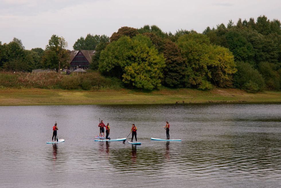 visit peak district   people learning to stand up paddle board on tittesworth water reservoir, uk