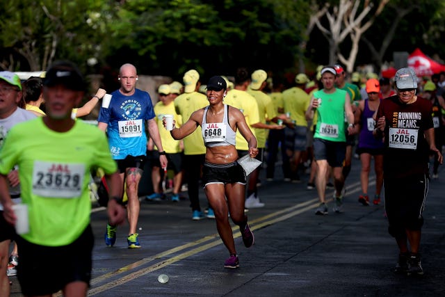 marathon runner with water cup in hand