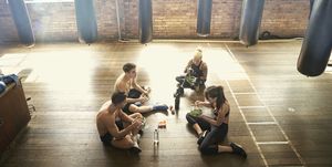 People sitting on floor in gymnasium eating salads