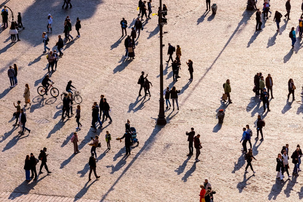 people walking on the city square at sunset, aerial view