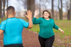 twee hardlopers in het park geven highfive