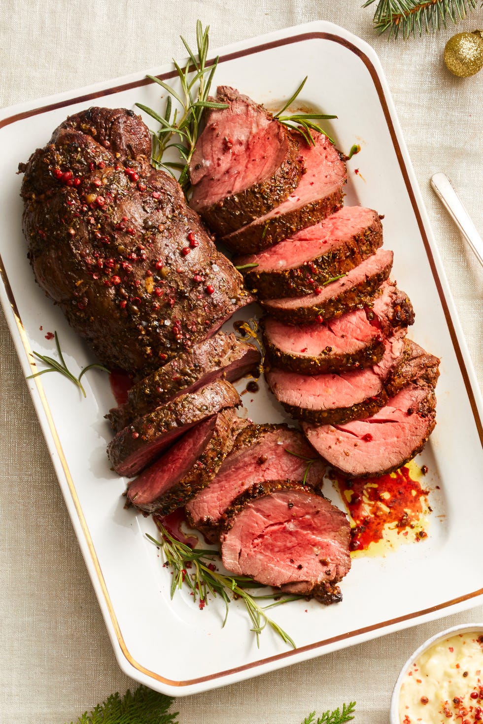 sliced peppercorn beef tenderloin on a white plate