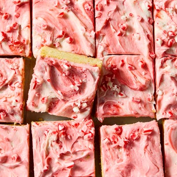 Peppermint Sheet Pan Bars cookie bars topped with pink ice and peppermint candy pieces