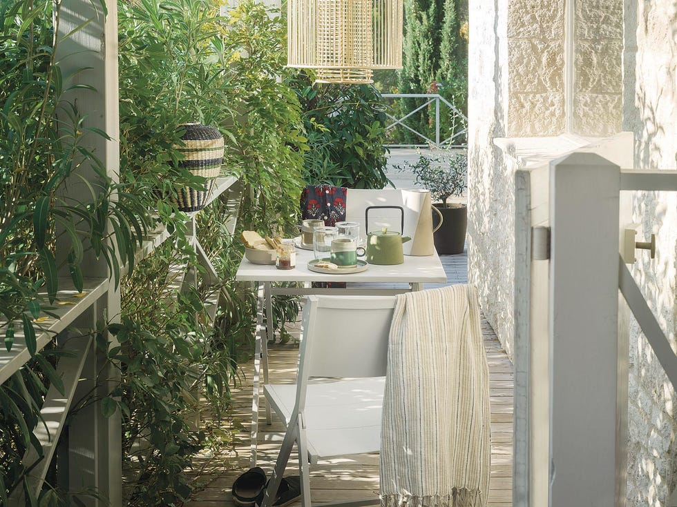 terraza pequeña con pequeño comedor blanco y plantas