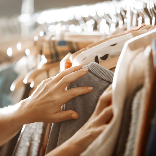 woman hands choosing dress in wardrobe