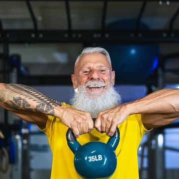 senior fitness man doing kettle bell exercises inside gym   fit mature male training in wellness club center   body building and sport healthy lifestyle concept