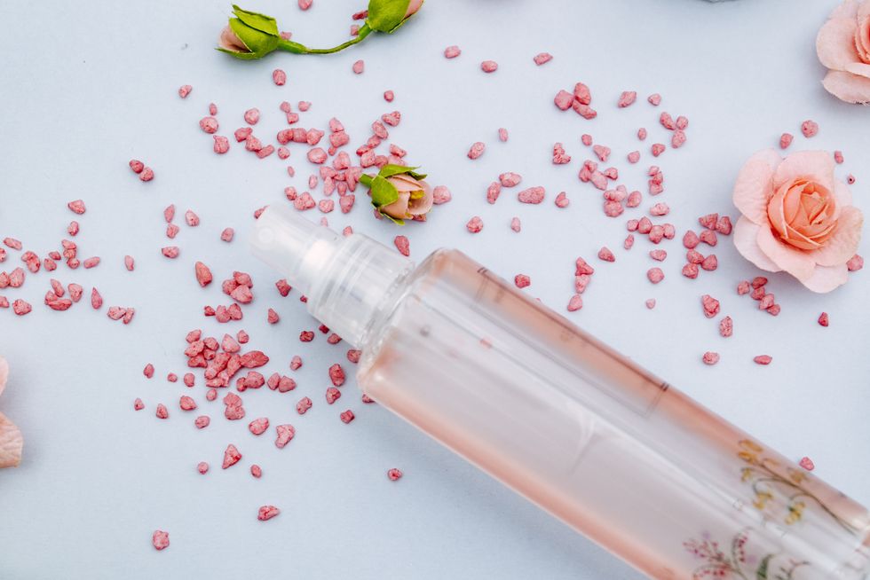 perfume bottle and rose petals top viewpastel tones