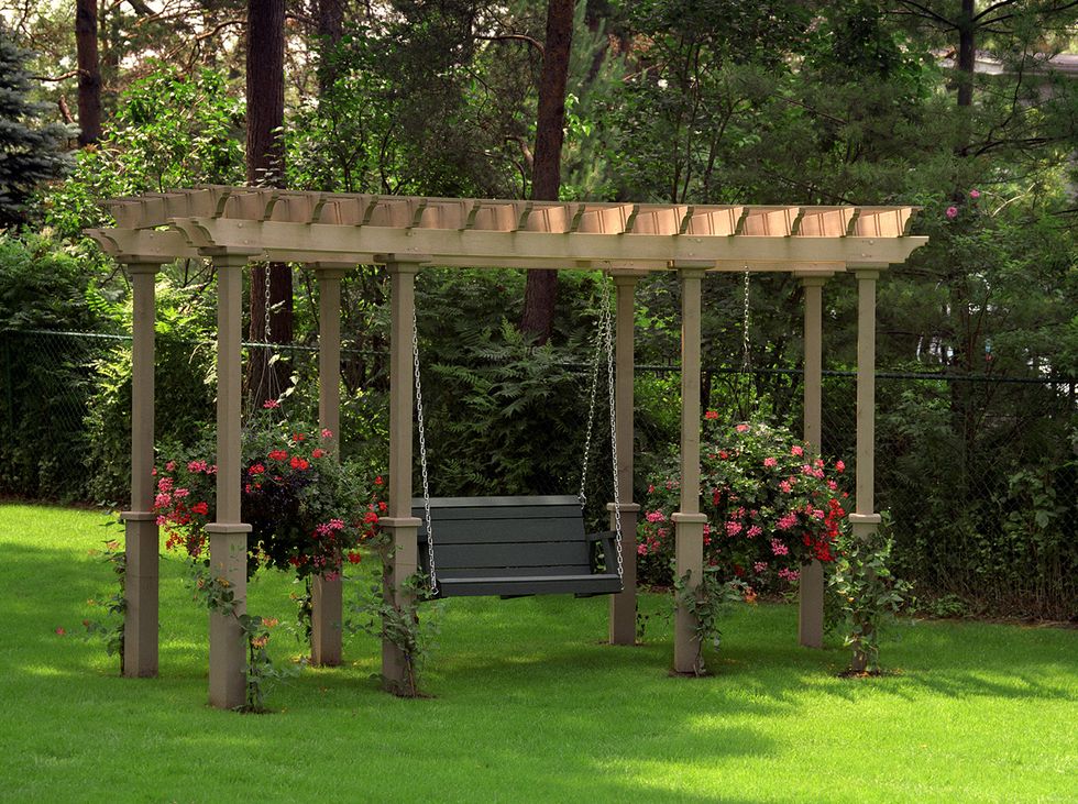 pergola ideas with an attached swing in a sunny garden