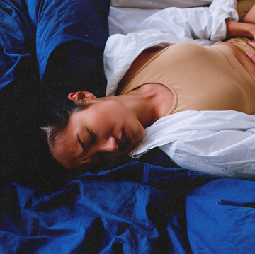 woman laying down holding her stomach