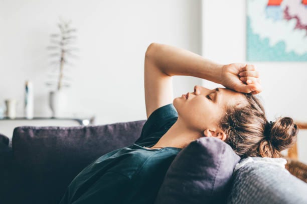 sad woman sitting on sofa at home