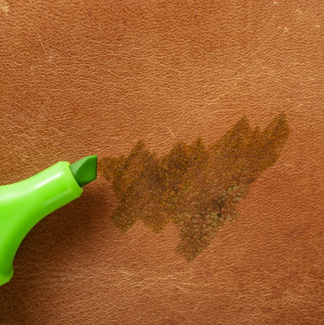 permanent green marker scribbling on red brown leather, close up