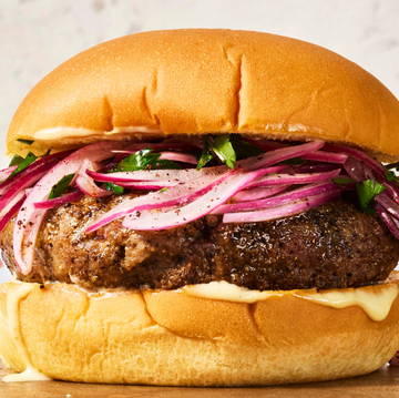 burgers topped with fresh herbs and pickled onions on cutting board burgers topped with fresh herbs and pickled onions on cutting board
