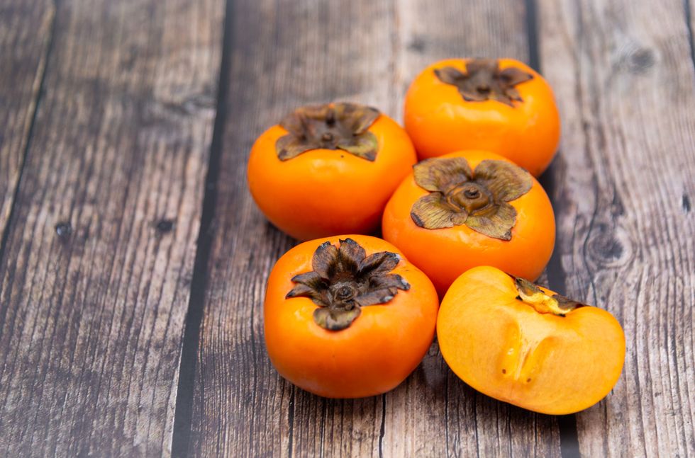 persimmon fruit on old wooden background, top view