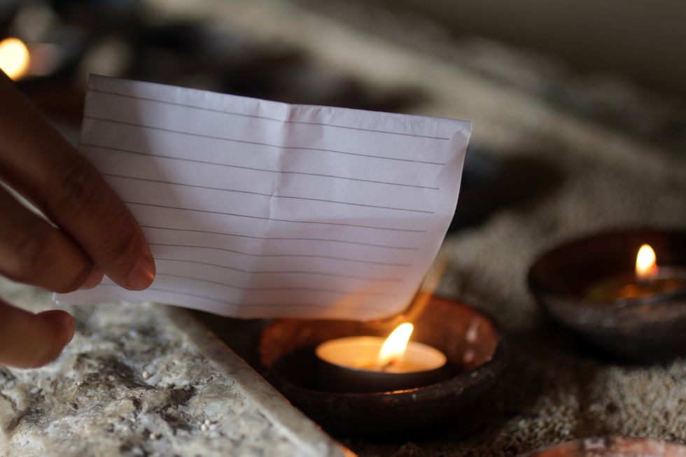 person burning white paper on a candle