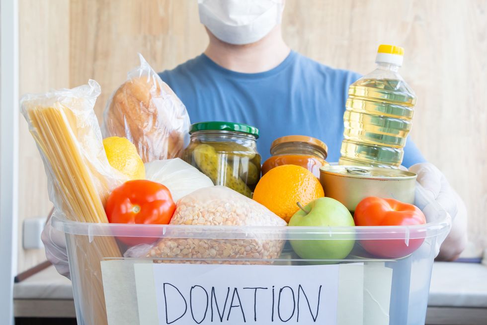 person holds donation box full of food