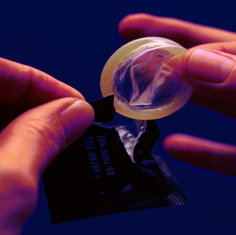 person removing condom from packet, close up