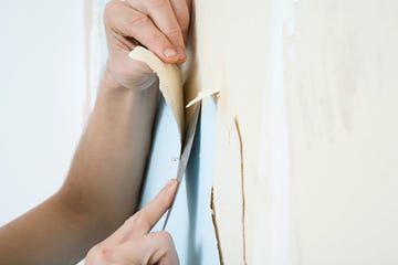 person removing wallpaper