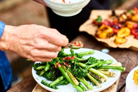 Person spooning sauce over freshly cooked green vegetable medley person spooning sauce over freshly cooked green vegetable medley