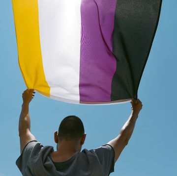 person waving a non binary pride flag