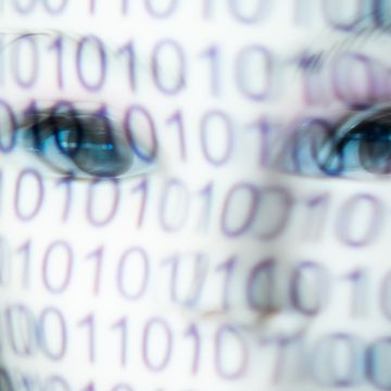 person with a white mask and a binary code on the mask. represents man and machine, programming, the virtual world and the future. moved image.