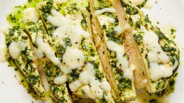 sliced chicken breast topped with pesto and melted cheese