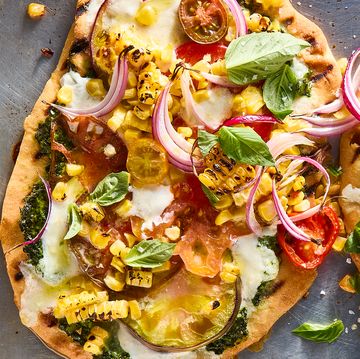 flatbread topped with pesto, corn, sliced onions, cheese, and tomatoes