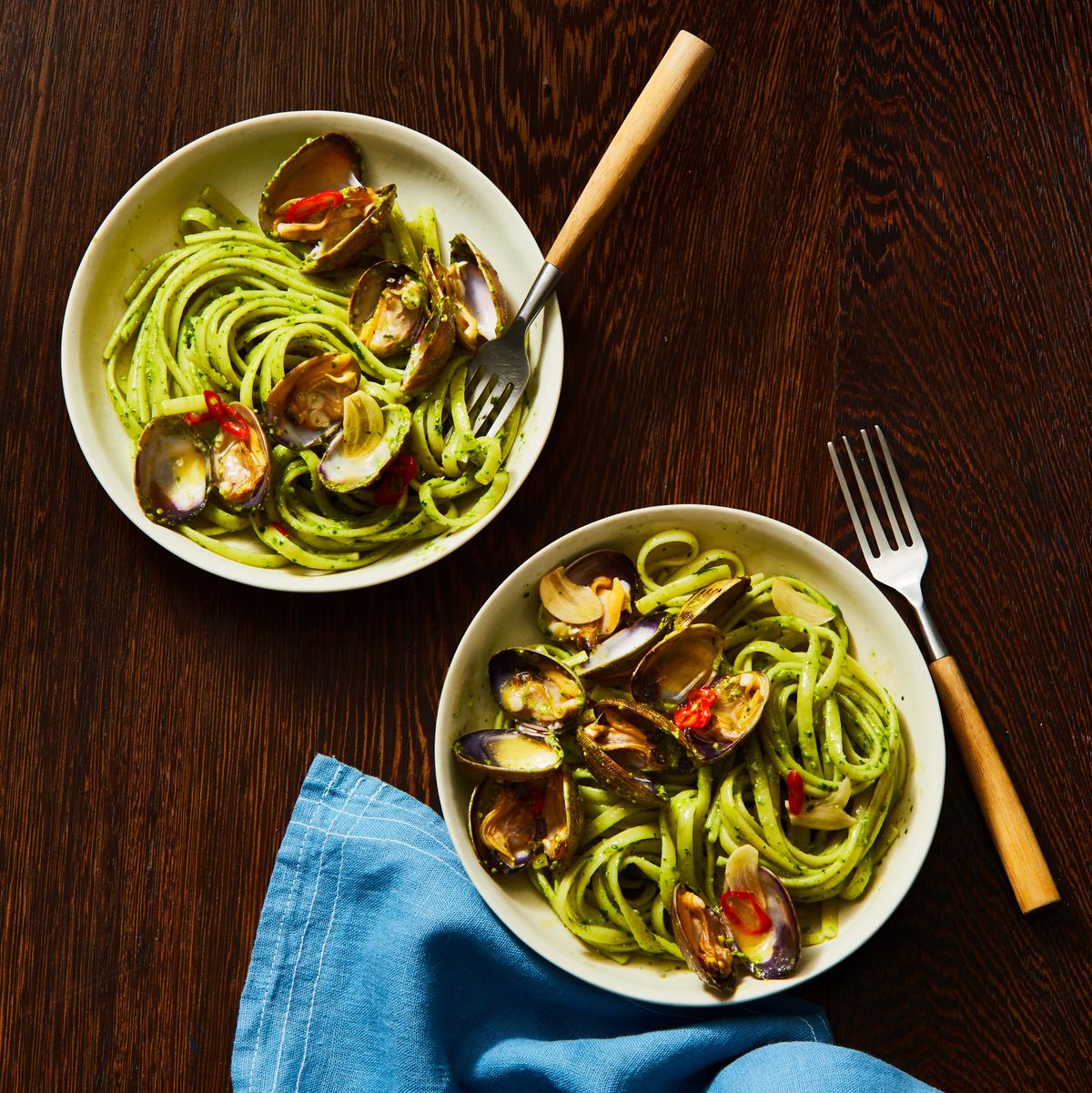 pesto linguine with clams in two bowls