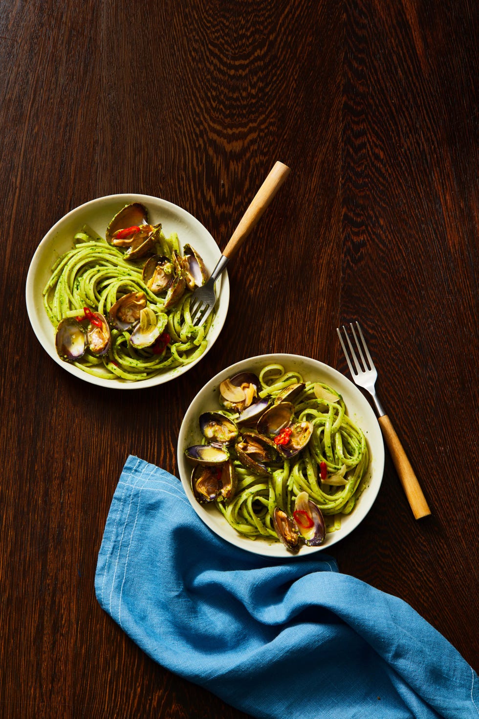 pesto linguine with clams in two bowls