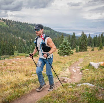 a runner wearing jeans running on a mountain trial a runner wearing jeans running on a mountain trial