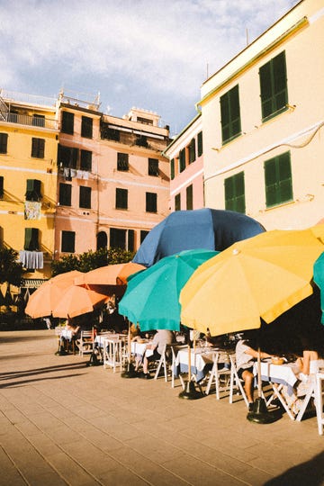 a group of people sit under umbrellas