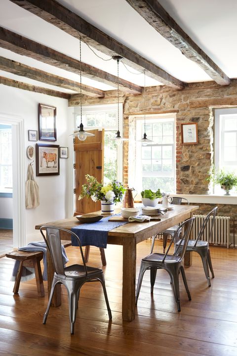 stone walls and wooden floors in a dining room with a table and chairs and bench