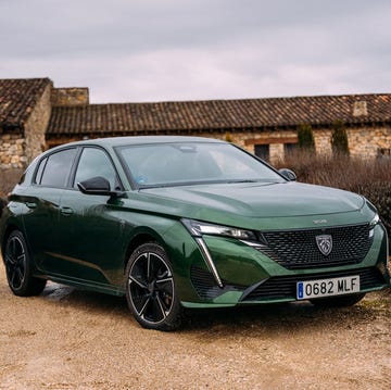 a green car parked in a gravel lot