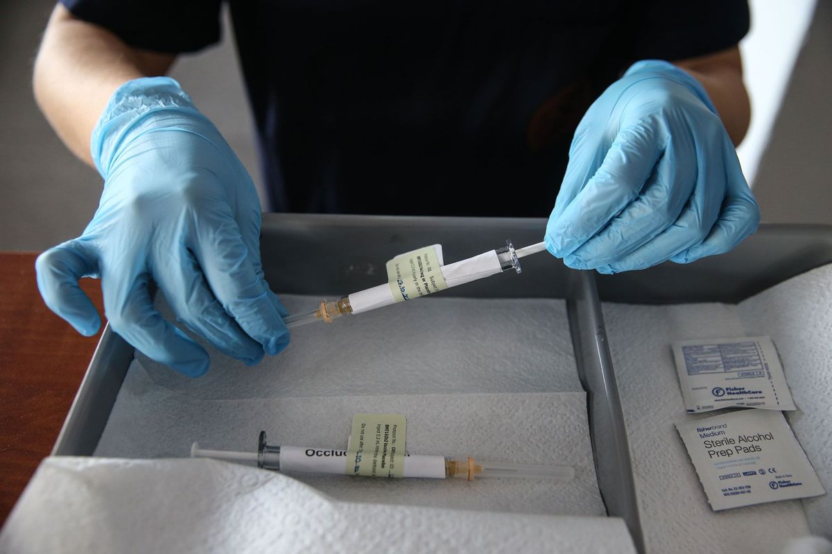 Op 27 oktober 2020 toont een medewerker van het Ibn Sinahospitaal van de Universiteit van Ankara in Turkije een injectienaald die wordt gebruikt tijdens de Fase 3test voor het inmiddels goedgekeurde COVID19vaccin van Pfizer en BioNTech