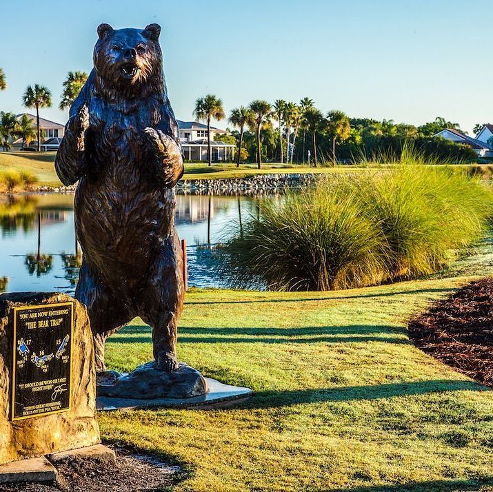 a statue of a bear by a pond