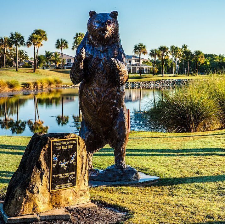 a statue of a bear by a pond