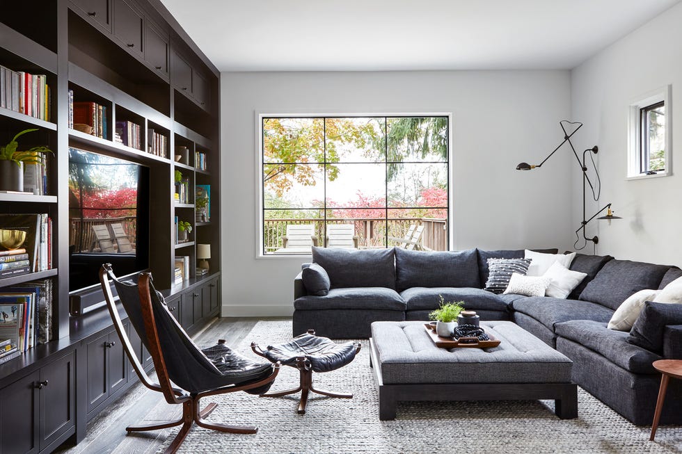 Family room custom rug and sconce shine a light on both sides of a noble soul Perennial linen chair and ottoman sectional Sigurd Lessel, Finch Hudson rug Custom ottoman custom, walleye wool 19th century Carriage House 19th Century Carriage House in Montclair, New Jersey Interior Design, Design by Elaine Santos, Architectural Minimal Modern Accents by Architect Windigo