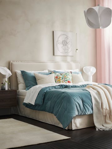 cozy bedroom featuring a bed with decorative pillows and a pendant light