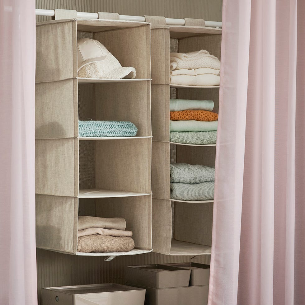 storage organizer with shelves containing folded clothes and a hat
