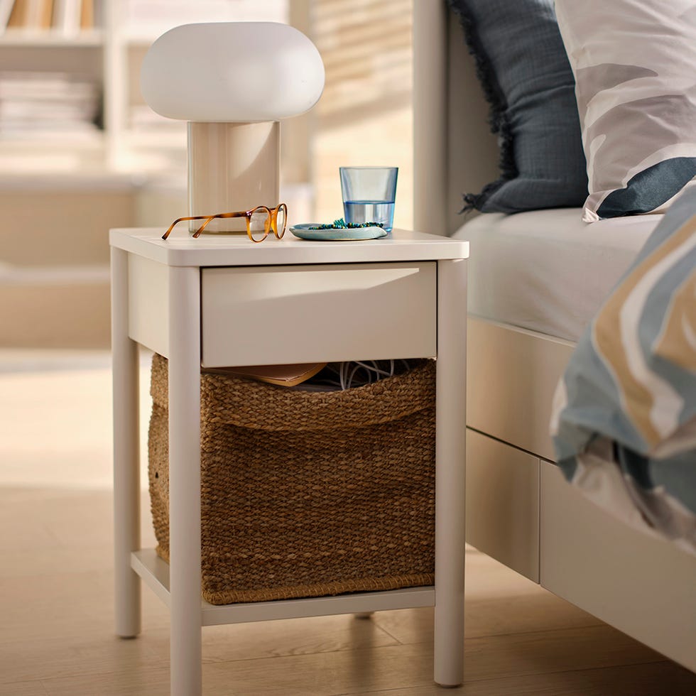 nightstand with a lamp glass of water eyeglasses and a decorative plate