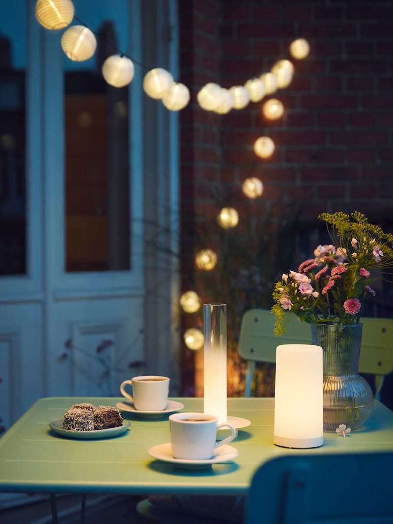 outdoor table setting with coffee dessert and decorative lighting