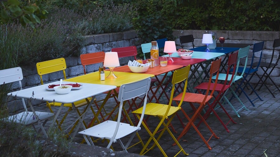 colorful outdoor dining setup with folding chairs and tables