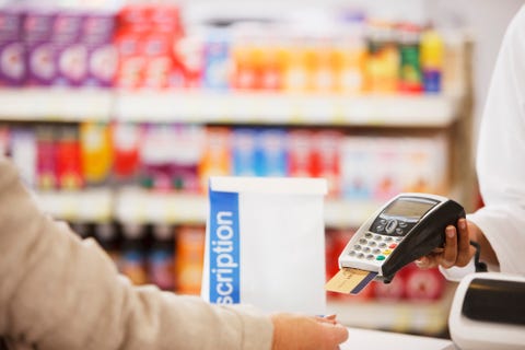 Pharmacist holding security device for customer in drug store