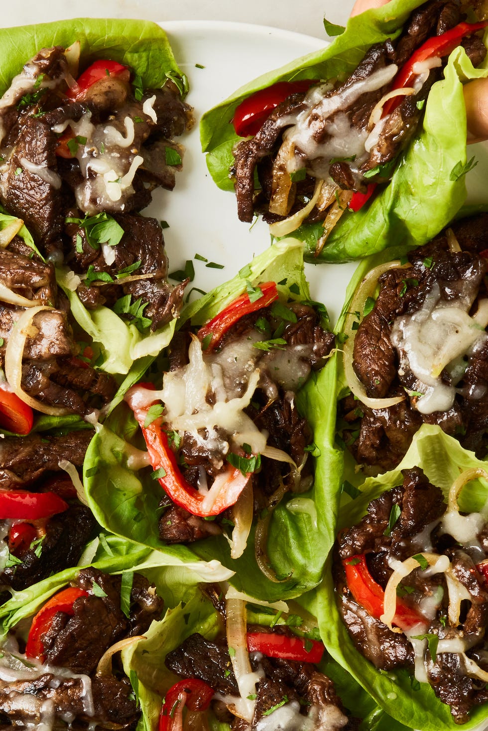 Philly Cheesesteak Lettuce Wraps philly cheesesteak with cheese and peppers in lettuce wraps