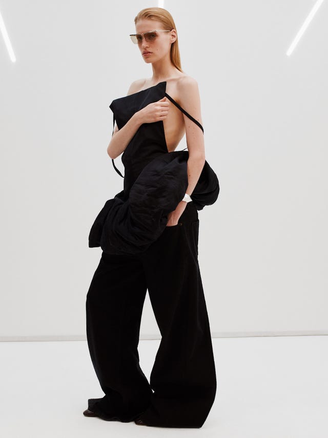 Desfile de moda con una modelo vestida con un atuendo negro vanguardista.
