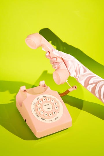 gloved hand picking up a landline phone